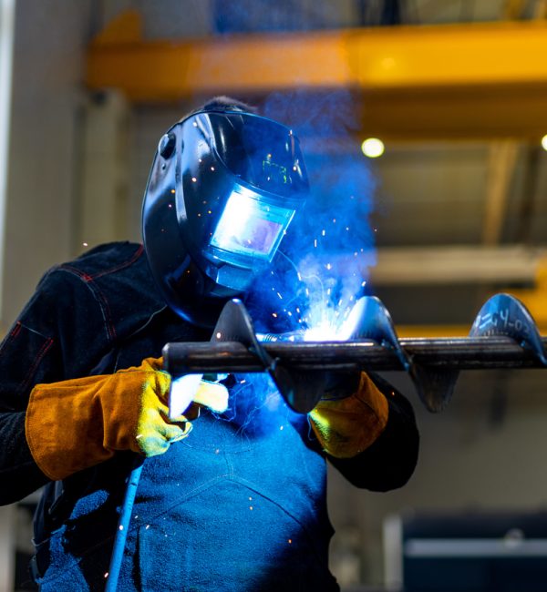 Factory metal worker welding. Welding specialist working with protective mask.